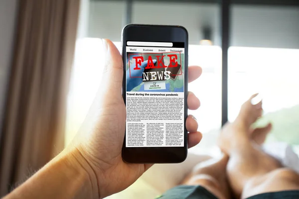 Man reading fake news or articles about covid-19 in a smartphone screen application. Mockup app website. Fake Newspaper portal. Media technology and modern lifestyle concept.