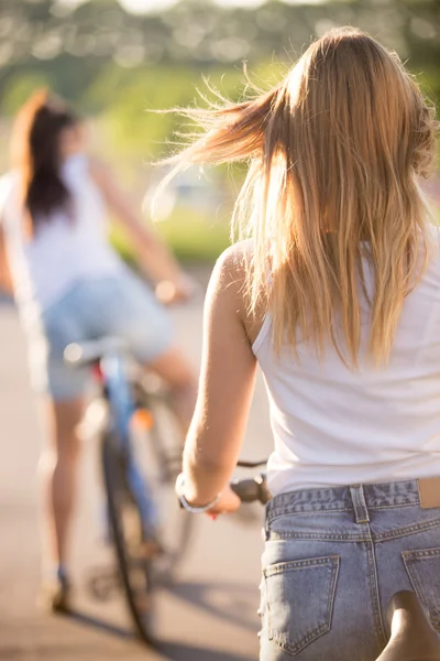 Young women on bicycles, rear view — Stock Photo, Image