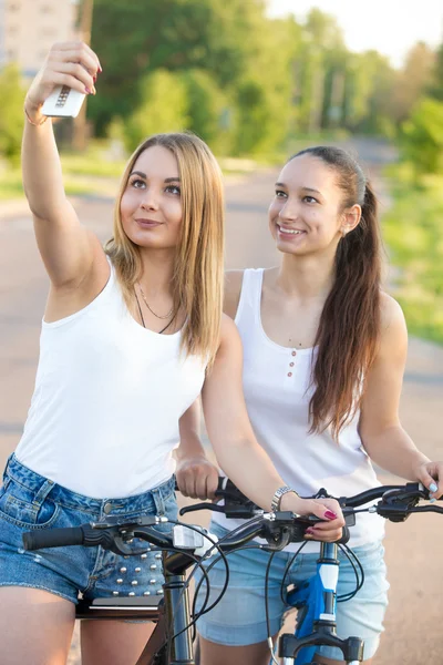 Smiling teenage girls taking selfie with cellphone — Stock Photo, Image