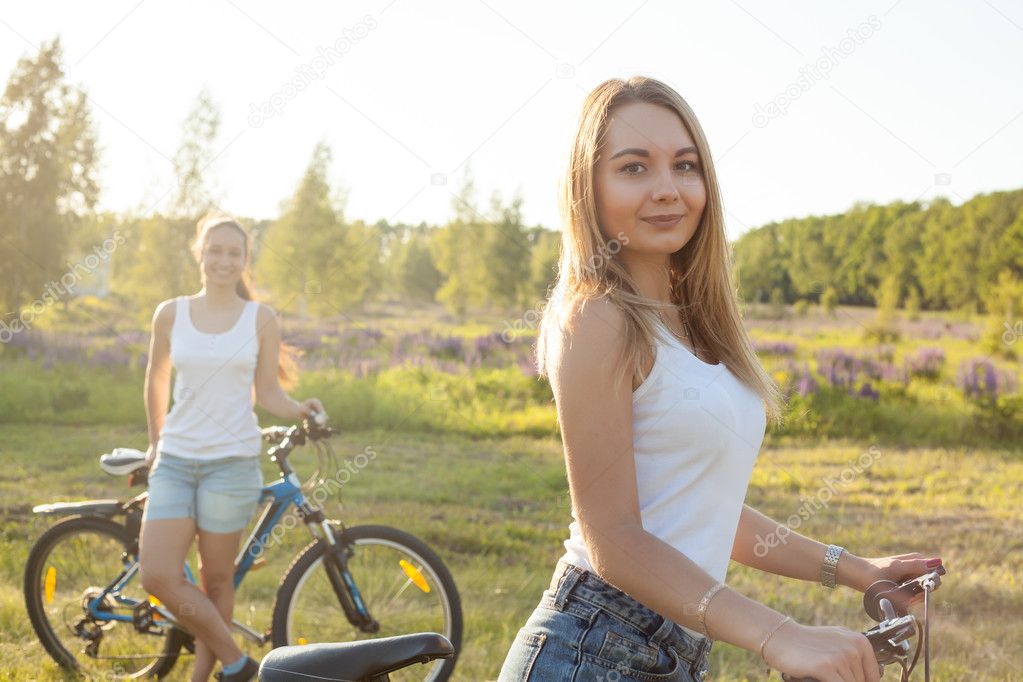 Portrait of two cute bicyclist young women