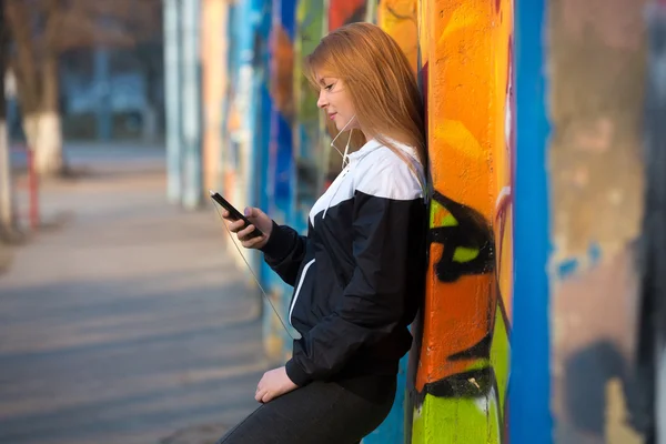 Chica corredor descansando con el teléfono móvil en la calle — Foto de Stock