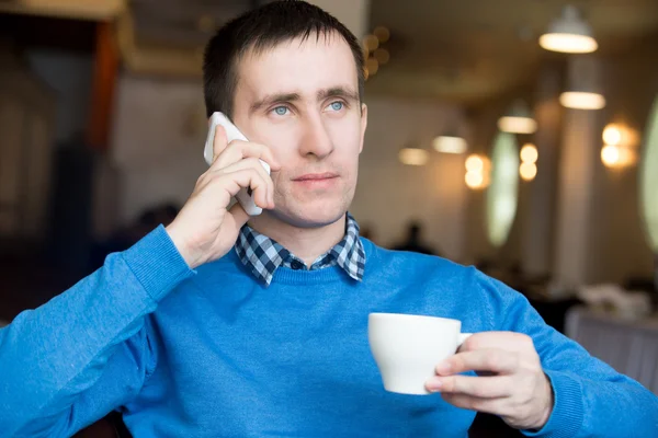 Young man making call at breakfast — 图库照片