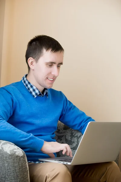 Jonge man met laptop binnenshuis — Stockfoto