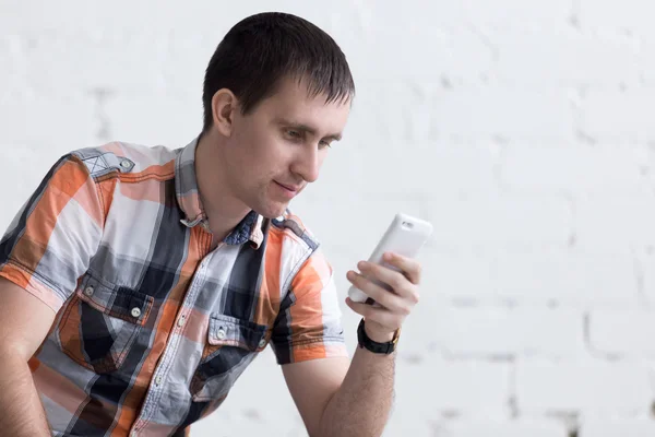 Jonge man met smartphone binnenshuis — Stockfoto
