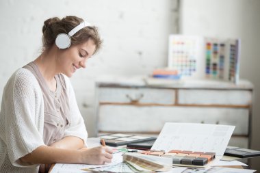 Neşeli genç kadın iş yerinde müzik dinliyor 