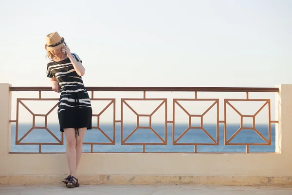 Young woman on phone on sea street — Stock Photo, Image