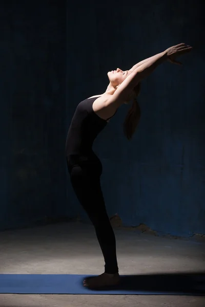 Schöne Yoga-Frau, die ardha chakrasana Pose macht — Stockfoto