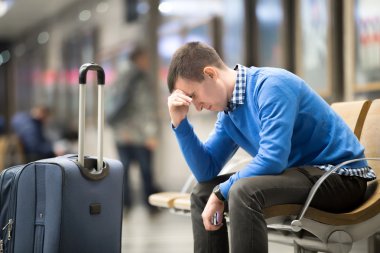 Young frustrated man at airport clipart