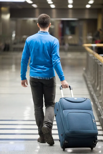 Traveler walking with suitcase at airport — Stockfoto