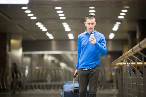 Traveler Guy använder telefon på flygplatsen — Stockfoto