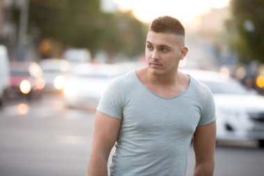 Genç adam şehirde yürüyor.