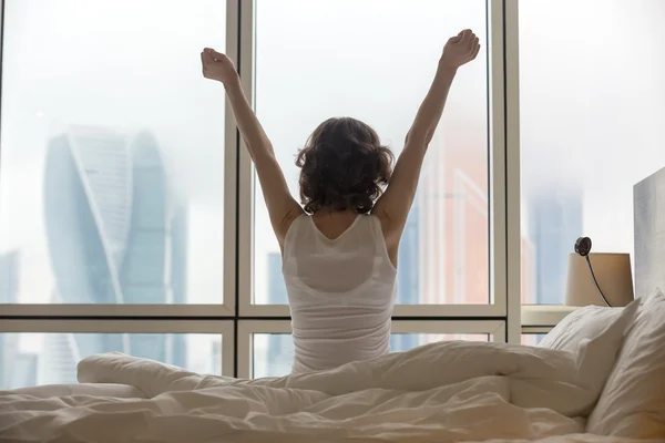 Mujer joven estirándose después de despertar — Foto de Stock