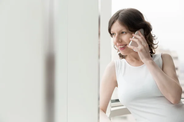 Щаслива жінка розмовляє по телефону в приміщенні — стокове фото