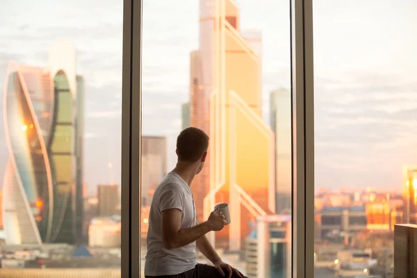 Man watching sunrise in window — Stock Photo, Image