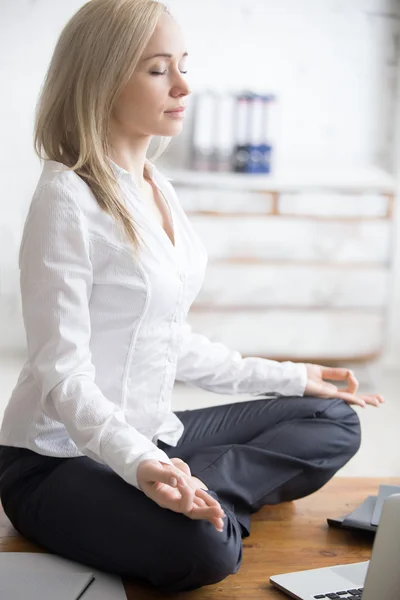 Business woman sitting in padmasana pose — Stock Photo, Image