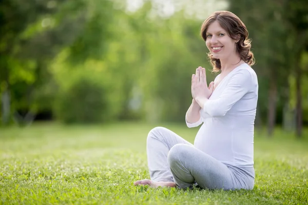 年轻怀孕模型在草地上冥想的肖像 — 图库照片