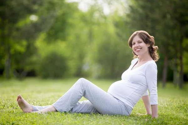 Retrato de mujer embarazada alegre relajándose en el parque — Foto de Stock