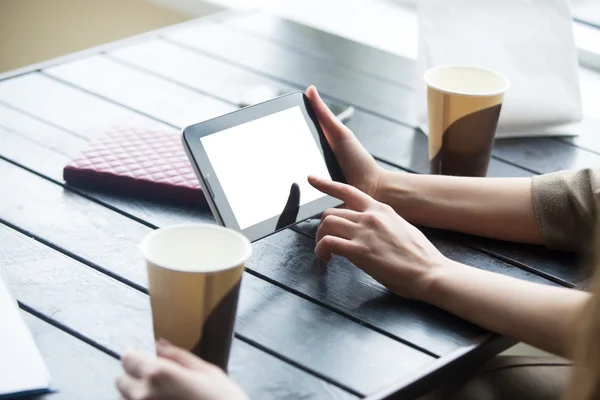 Mujeres manos sosteniendo la tableta con pantalla blanca en blanco en la cafetería. Clos. —  Fotos de Stock