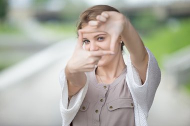 Bir çerçeve yapmak için elleri kullanarak eğlenceli kadın Portresi