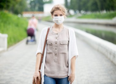 Portrait of sick woman wearing protective mask against infective clipart
