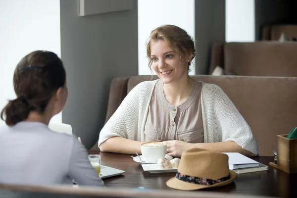 Dos mujeres hermosas jóvenes tomando café en la cafetería — Foto de Stock