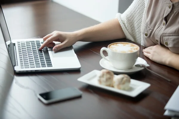 Primer plano de las manos femeninas que trabajan en el ordenador portátil en la cafetería — Foto de Stock