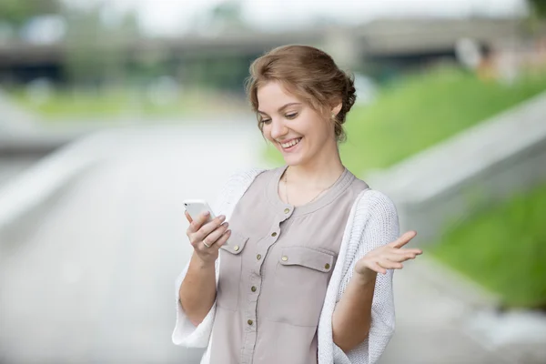 Retrato de mujer alegre mirando la pantalla del teléfono inteligente —  Fotos de Stock