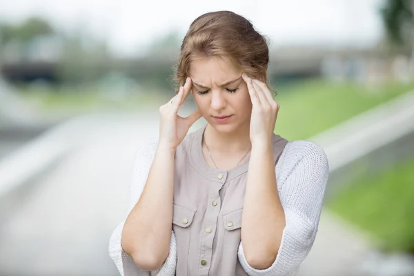 Portrait of stressed woman with headache outdoors — Stock Photo, Image