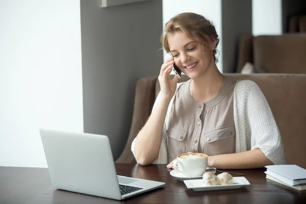 Half-length portrait of happy woman using phone and laptop in ca — Stock Photo, Image