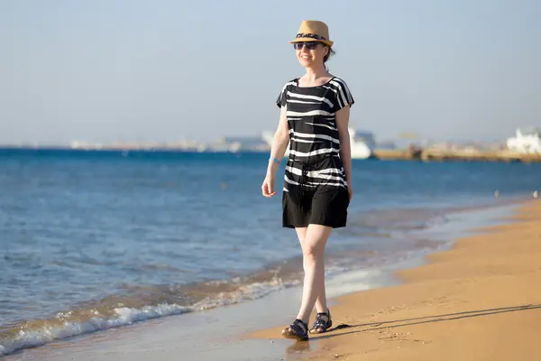 Mladá šťastná usmívající se žena chůze na pláž — Stock fotografie