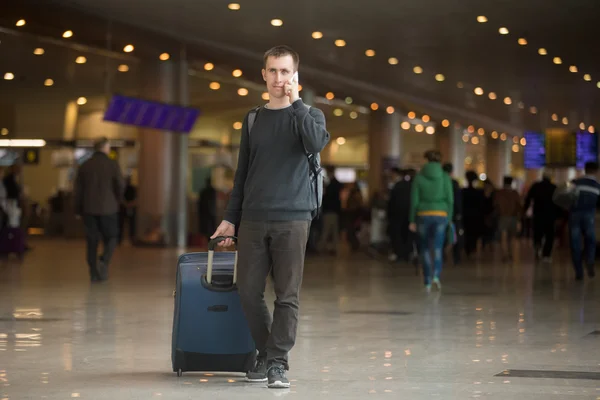 Young traveler in airport making call — Stock Photo, Image