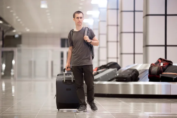 Young man got luggage at conveyor belt — Stock Photo, Image