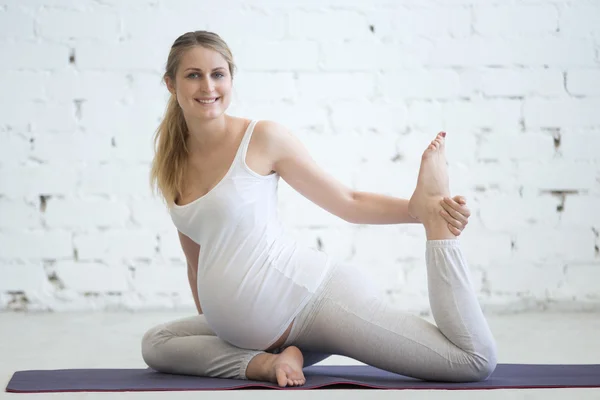 Hamile genç kadın prenatal Eka Pada Rajakapotasana yoga yapıyor — Stok fotoğraf