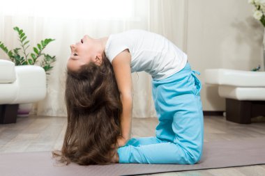 Evde yoga yapan mutlu çocuk kız 