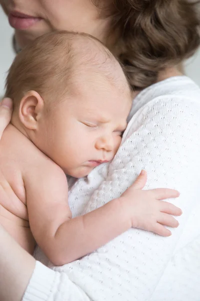 Молода щаслива мати ніжно обіймає новонароджену дитину — стокове фото
