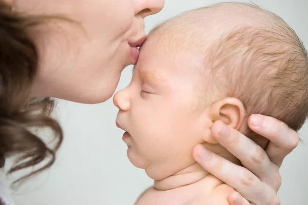 Jovem mãe beijando seu bebê recém-nascido. Close-up — Fotografia de Stock