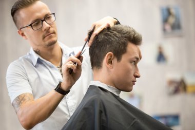 Çekici genç adamın saç kesimine dikkat çekme portresi