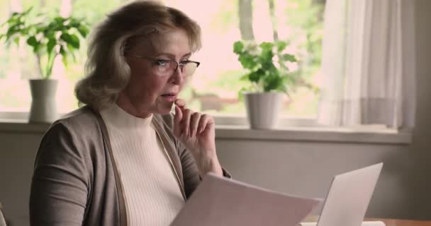 Mature woman sit at table holding letter read good news — Stock Video