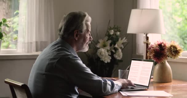 बुजुर्ग आदमी लैपटॉप टाइपिंग पाठ का उपयोग करता है सुधार करता है — स्टॉक वीडियो