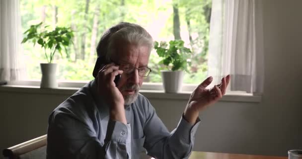 Hombre mayor hablando con teléfono inteligente expresar quejas resolver problemas de forma remota — Vídeos de Stock