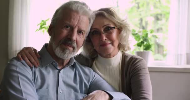 Potret close up pasangan usia merangkul tersenyum melihat ke kamera — Stok Video