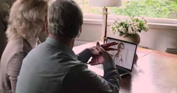 Casal idoso tendo consulta on-line com médico por chamada de vídeo — Vídeo de Stock