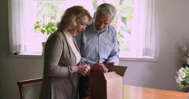 Pareja envejecida paquete abierto se siente satisfecho por los servicios de entrega segura — Vídeos de Stock
