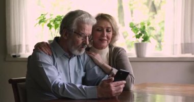 Akıllı telefon kullanan yaşlı eşler satıştaki mesajları okuyunca mutlu oluyorlar.