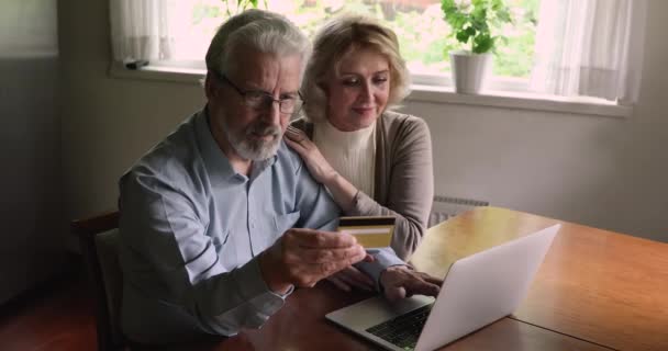 インターネットで購入するラップトップクレジットカードを使用している高齢者の配偶者 — ストック動画