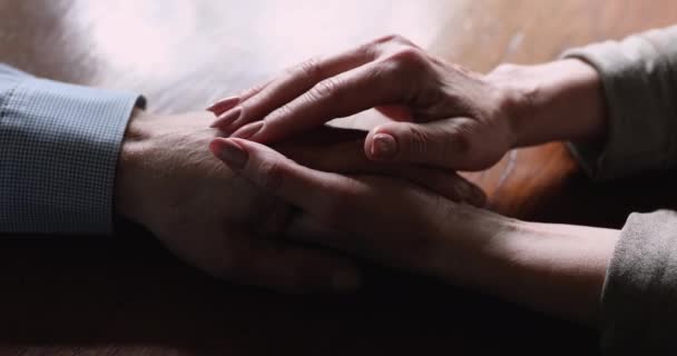 Старая жена утешает мужа гладит его руку, чтобы обеспечить поддержку крупным планом — стоковое видео