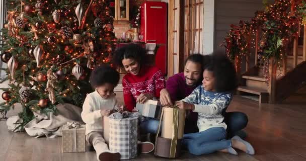 Feliz familia africana con niños abriendo cajas de regalo celebrando la Navidad — Vídeo de stock