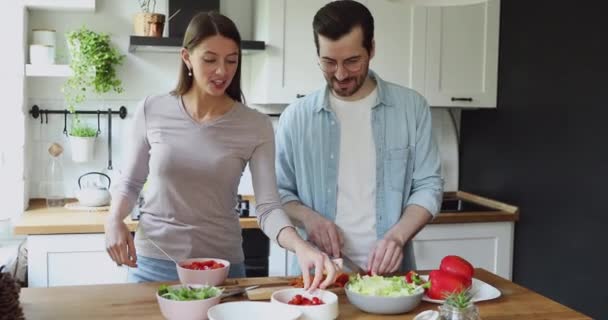 Houden van jonge vrouw voeden lachende echtgenoot, bereiden van voedsel samen. — Stockvideo