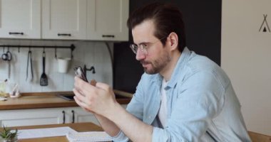 Çevrimiçi zaferi kutlayan duygusal pozitif genç yakışıklı adam..