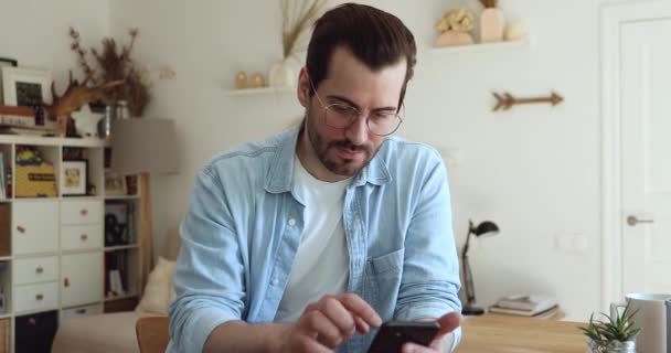 Viciado em tecnologia jovem bonito homem assistindo vídeo engraçado. — Vídeo de Stock